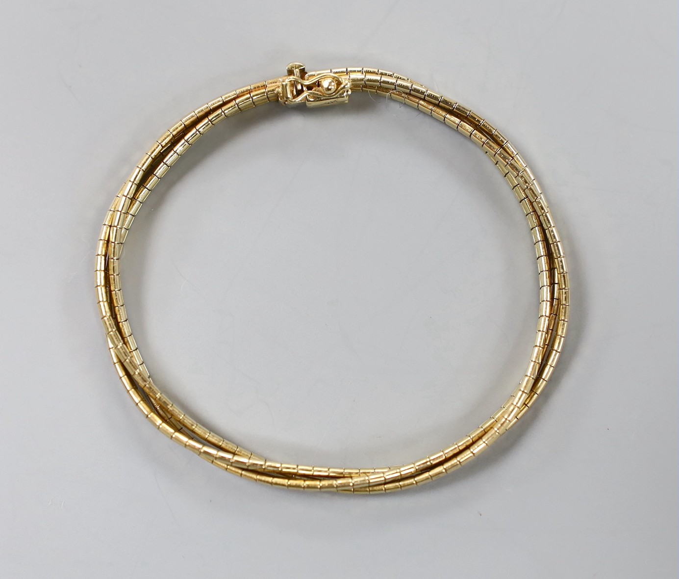 A modern three colour 9ct gold triple strand interwoven bracelet, 17cm, 15.3 grams.